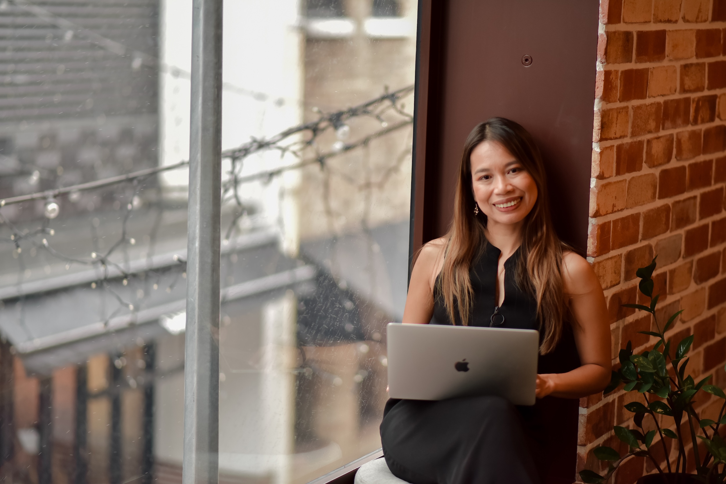 Fon Ward, technical SEO specialist at Search Studio, working at window with laptop