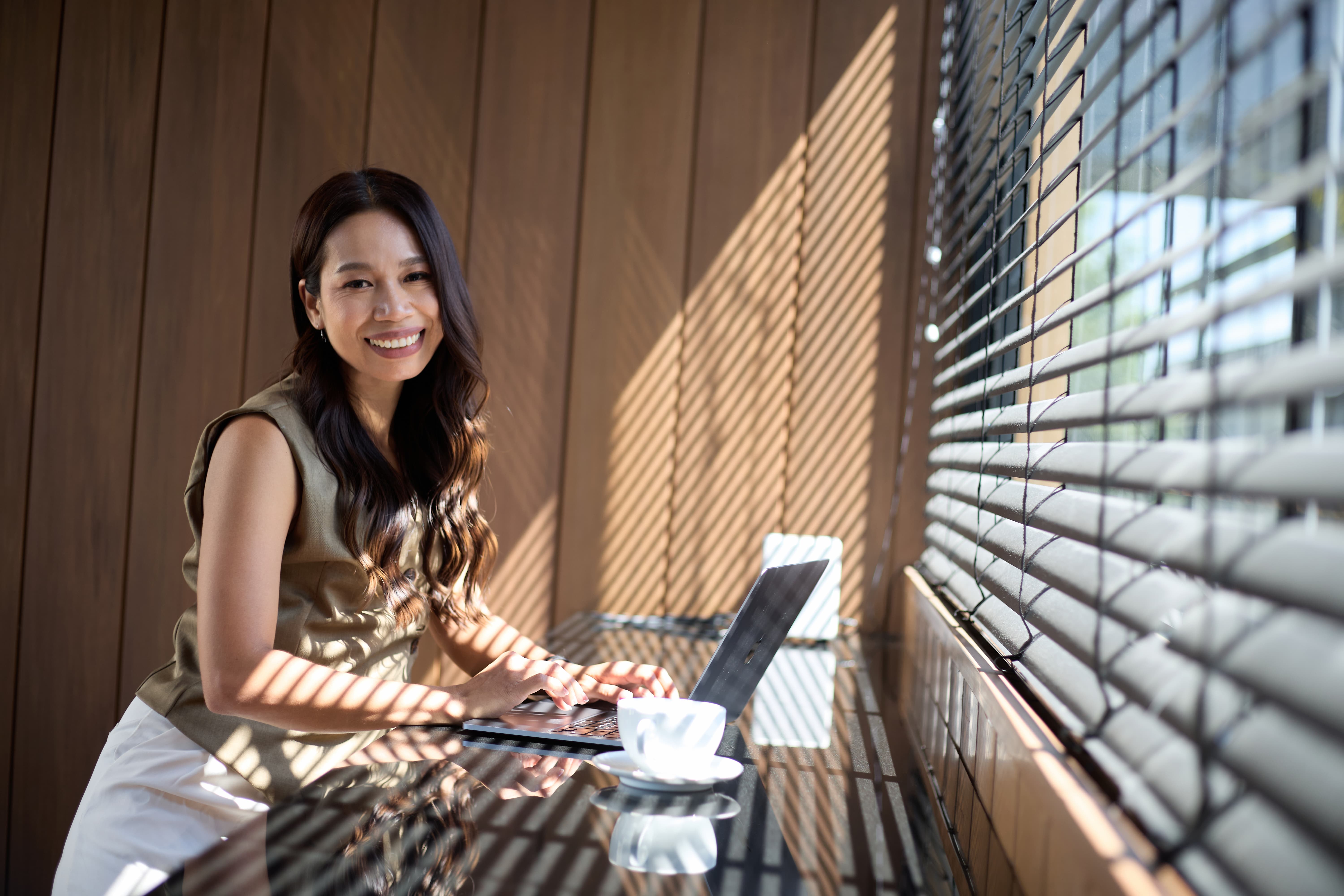 Fon Ward, link building specialist at Search Studio, working at a sunlit table