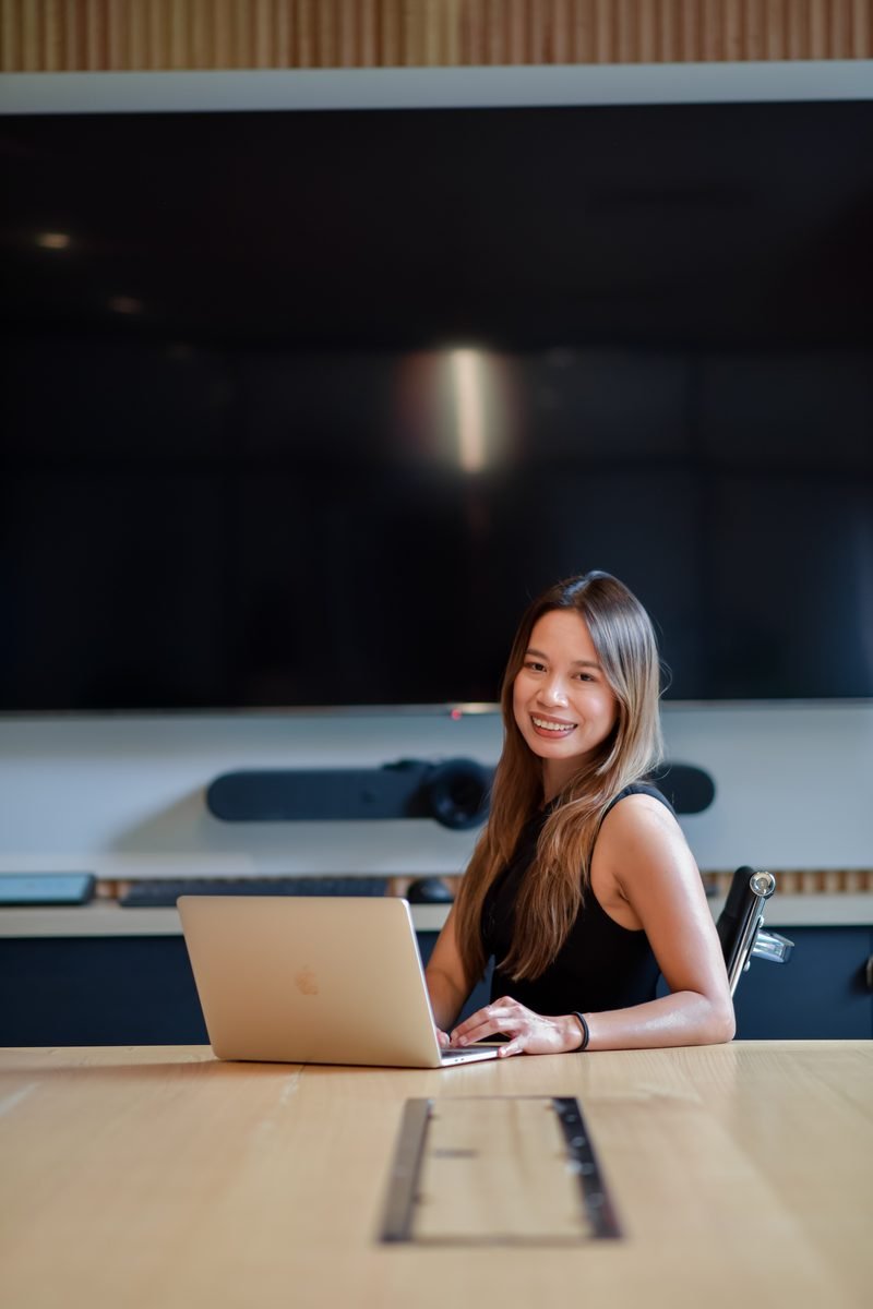 Fon Ward working at a boardroom table on her laptop, B2B SEO consultant