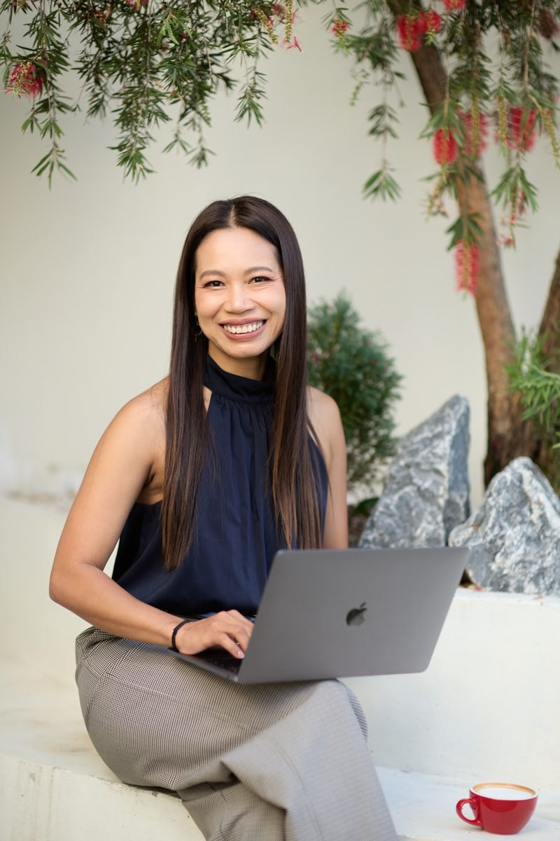 Fonthip Ward, SEO consultant, seated in a Brisbane workspace with laptop
