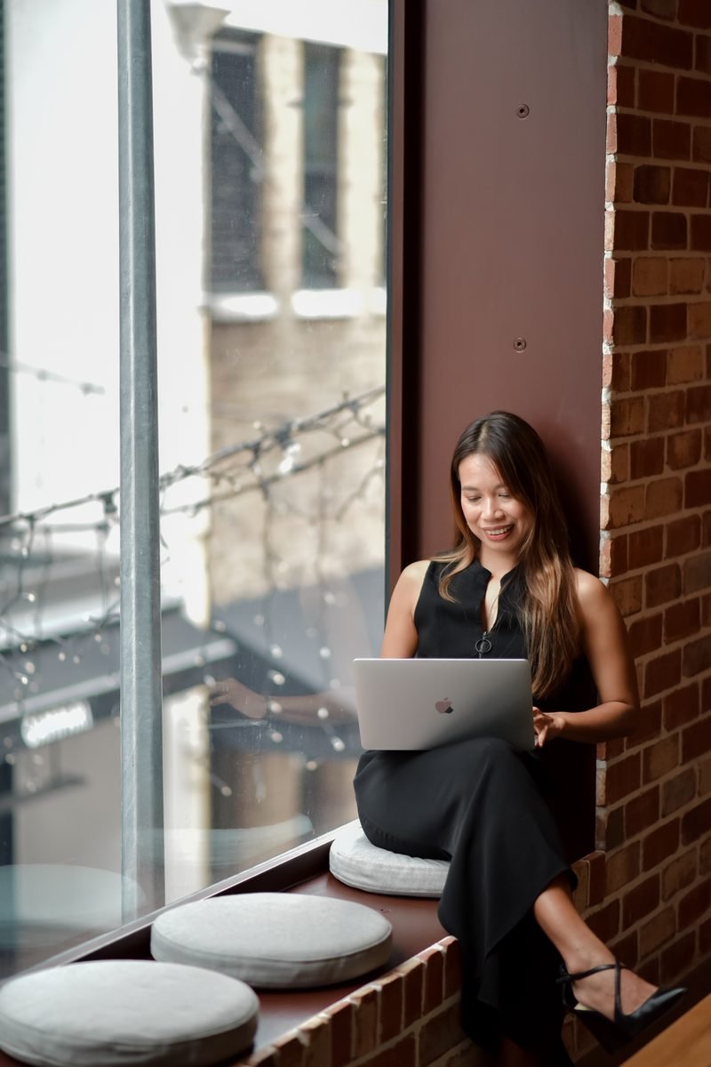 Fon Ward, SEO consultant for cleaning businesses at Search Studio, working on a laptop at a window seat