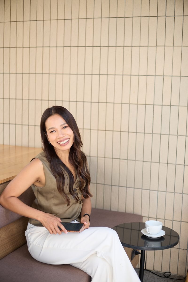 Fon Ward, real estate SEO consultant at Search Studio, seated in a cafe booth with her phone