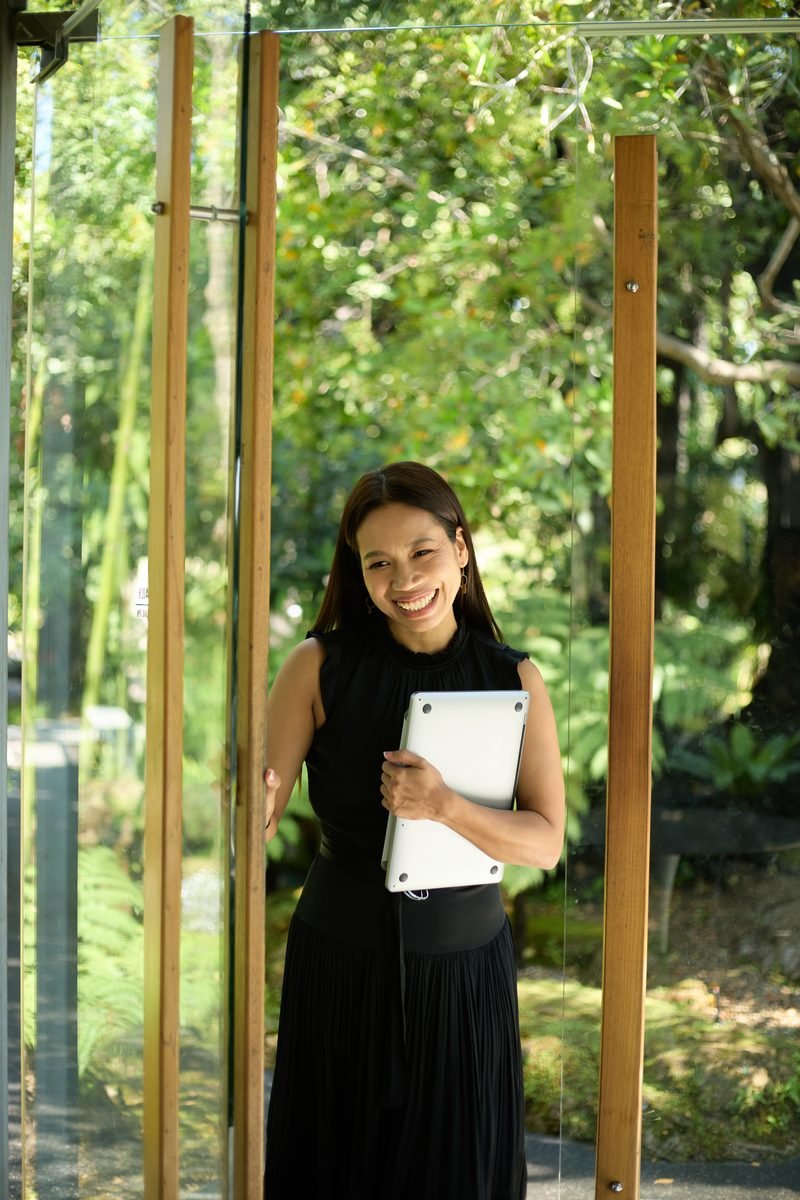 Fon Ward holding a laptop in a bamboo garden, SEO consultant for chiropractic clinics